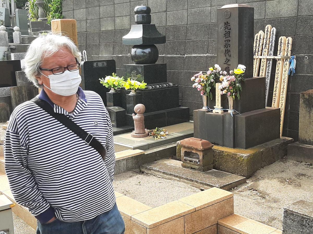 Japaner mit Maske allein auf dem Friedhof