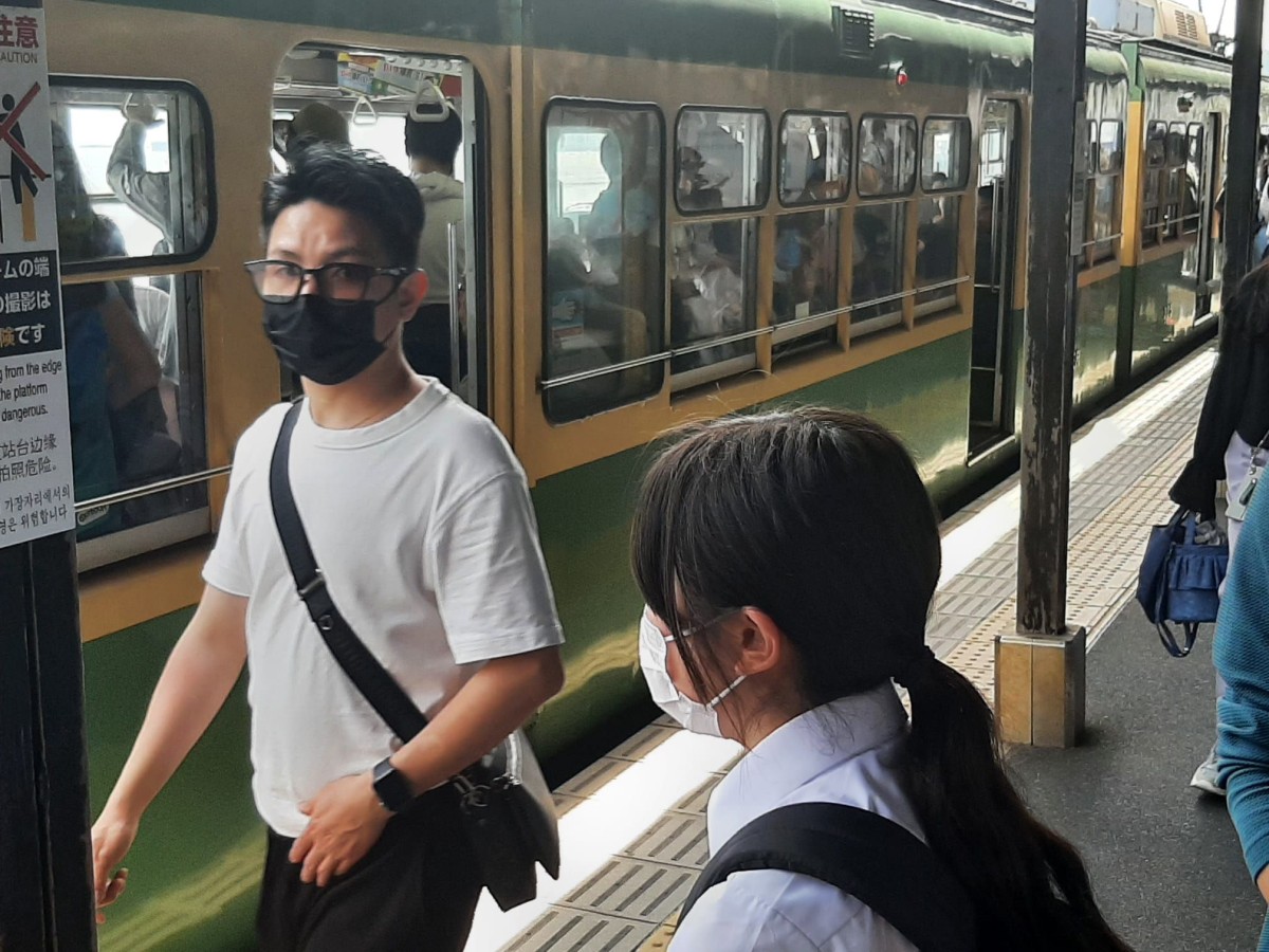 Menschen mit Maske am Bahnhof ind Japan